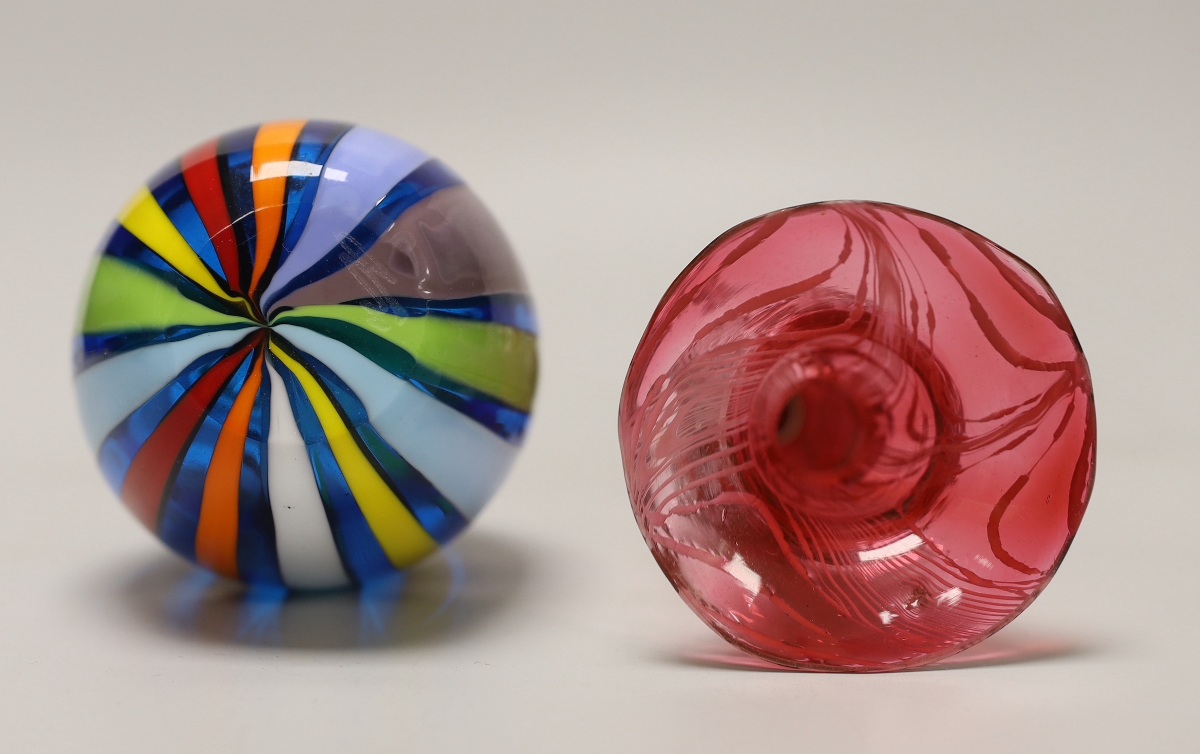 A Victorian hollow ruby glass candlestick with combed trailed decoration together with a Venetian glass striped vase (no maker's mark), the largest 25cm high